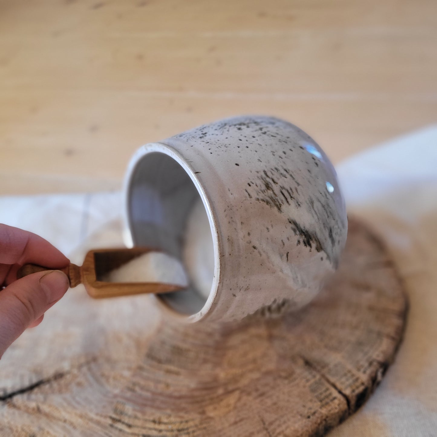Handmade gray ceramic salt pig with a speckled glaze and a small wooden spoon | Jogita Art Studio