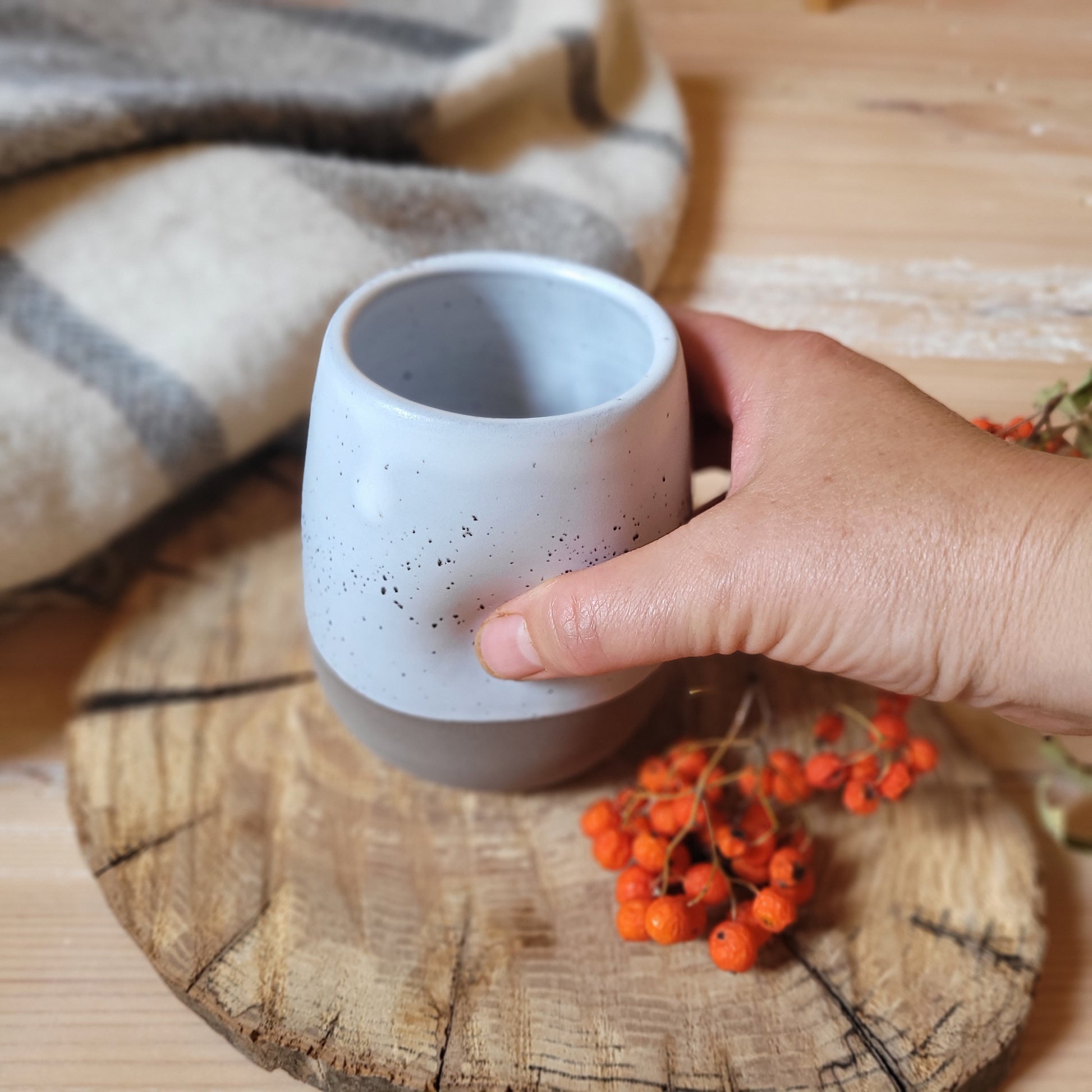write Alt Text: A unique and functional piece for everyday use.
This charming tumbler is handcrafted from durable ceramic and features a stylish gray base with a speckled white glaze, adding a touch of rustic elegance. The dimples along the sides provide a comfortable grip and a unique aesthetic.
Perfect for your favorite beverage, this tumbler is both stylish and functional. It's generous 
400ml capacity makes it ideal for coffee, tea, or your favorite cold drink.