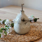 Handmade ceramic oil bottle with white glaze and speckles, showcasing its unique artisanal beauty. Perfect for adding a sustainable touch to your kitchen countertop.