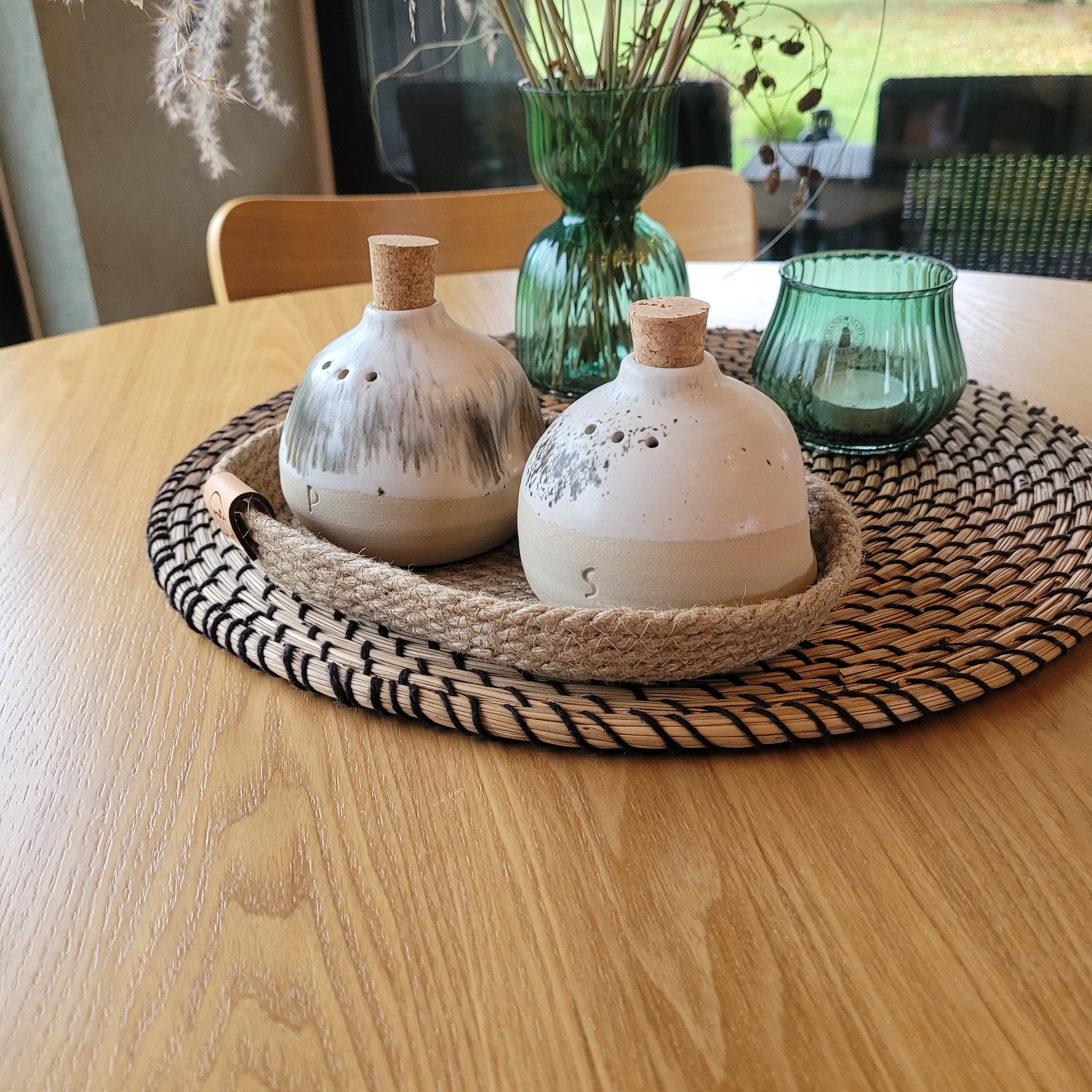 Beautifully detailed ceramic salt and pepper shakers with a natural jute basket for a touch of elegance.