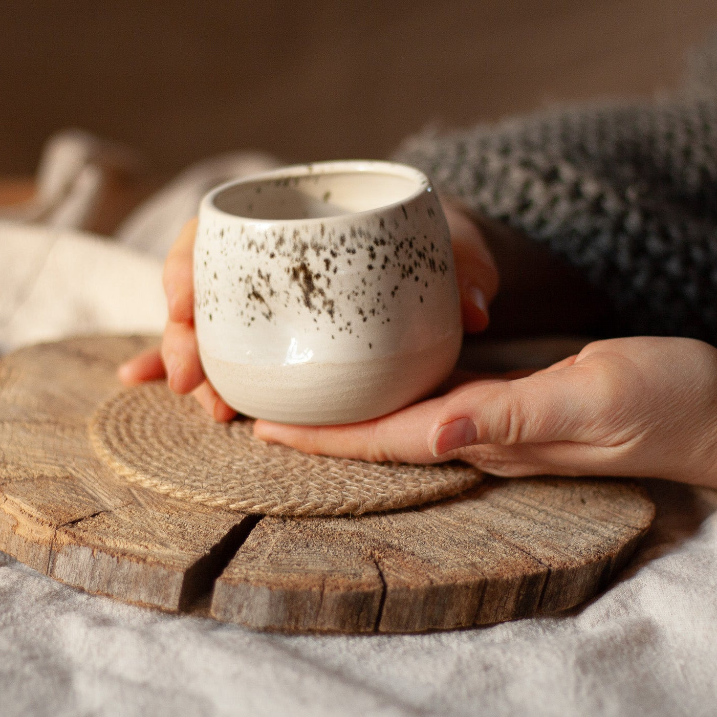 Close-up of a white handmade ceramic espresso cup showing the unique thumb rest indentation