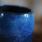 Nahaufnahme des Rands und des dunkelblauen Inneren einer handgefertigten Steingut Tasse mit reaktiver Glasurstruktur