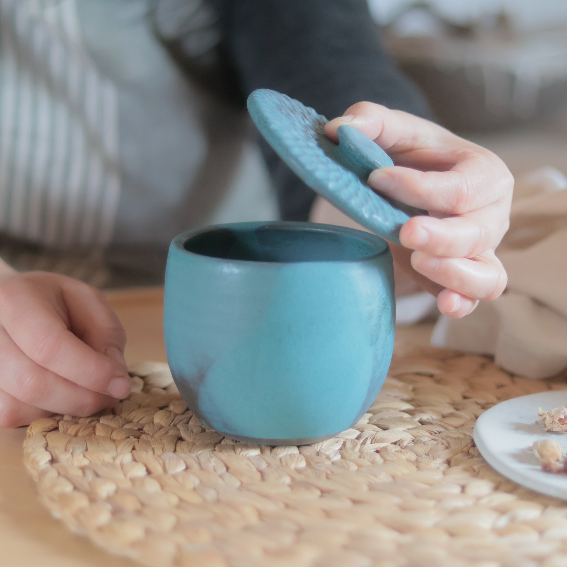 Gros plan sur le couvercle texturé tamponné d'un sucrier en grès turquoise