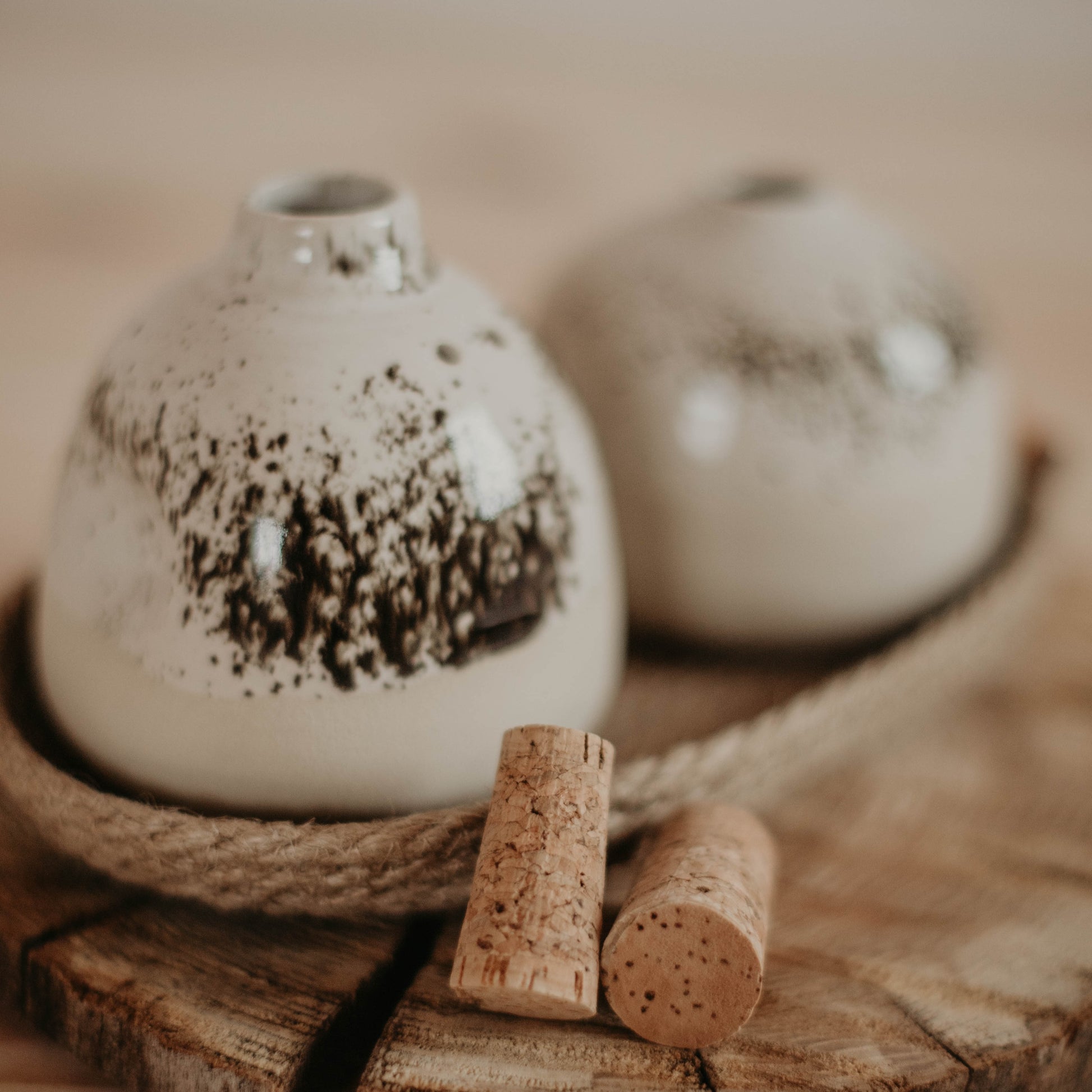 Dazzling handcrafted ceramic salt and pepper shakers, delicately painted with a speckled glaze, accompanied by an elegant jute basket.