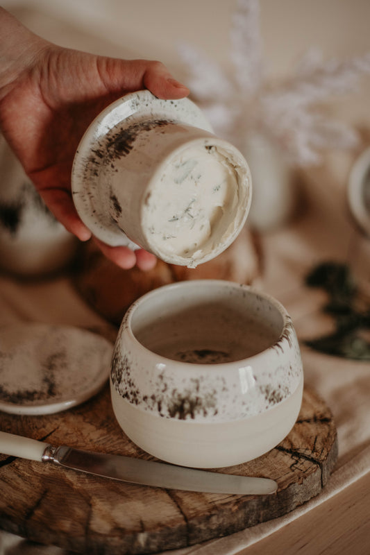 An array of different dishes, including the French butter dish, that are part of a French table setting.