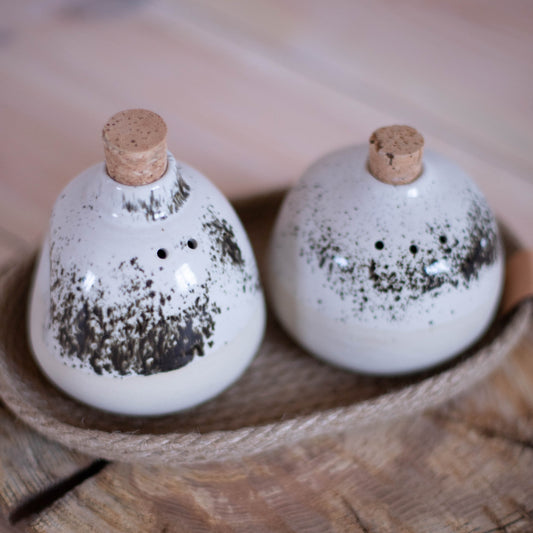 Handcrafted ceramic salt and pepper shakers in a timeless white speckled glaze.
