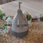 An exquisite handmade oil dispenser cruet made of stoneware pottery with a speckled white glaze. Perfect for sprucing up your kitchen countertop and storing oils, sauces, vinegar, and more