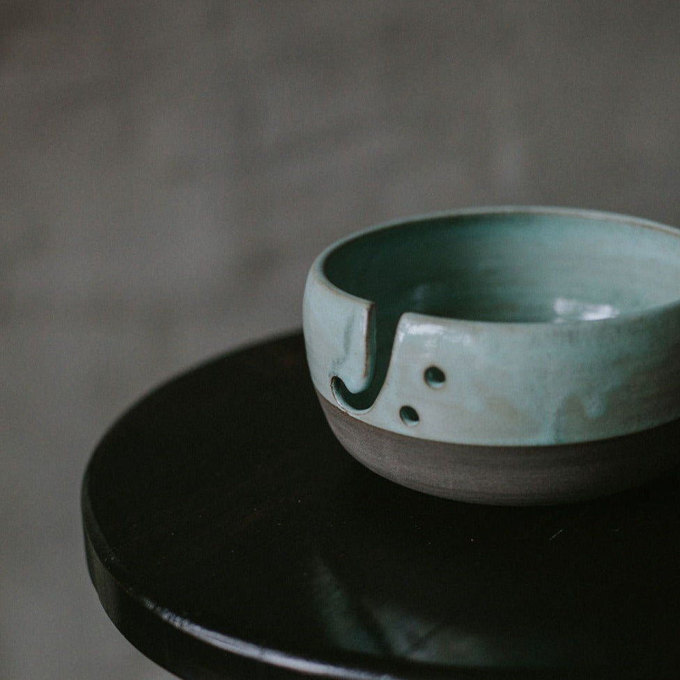 Ceramic yarn storage bowl with a unique speckled glaze, ideal for keeping your yarn collection neatly stored.